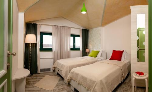 a hotel room with two beds with red and green pillows at Pensiunea Floarea Soarelui, Piscu in Piscu