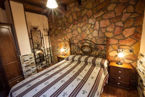 a bedroom with a bed in a stone wall at Alojamientos Rurales Benarum con Spa in Alpujarra De La Sierra