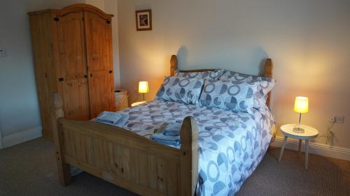 a bedroom with a bed with a blue and white bedspread at Connemara Farmhouse in Galway