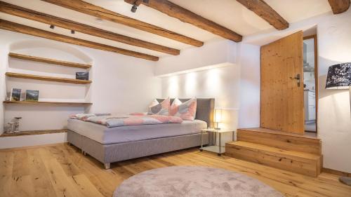 um quarto com uma cama num quarto com tectos em madeira em StuWip alps Appartement Sonnenstein em Fulpmes
