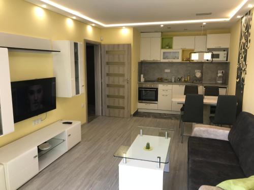 a living room with a couch and a tv and a kitchen at Sunrise Beach A4, Sarafovo in Burgas City