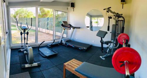a gym with several tread machines and a window at VILLA L'ESTAQUE in Armação de Pêra