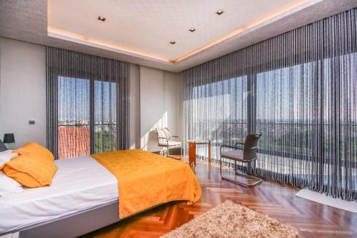 a bedroom with a large bed and large windows at ORIGINE RENTALS AN2 in Hurmaköy