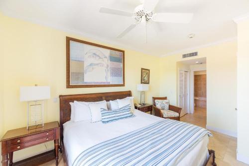 a bedroom with a bed with a blue and white striped blanket at Villa Renaissance Grace Bay in The Bight Settlements