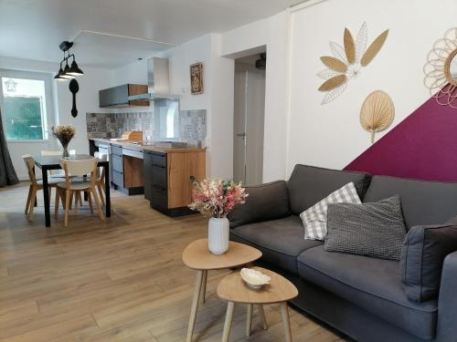 - un salon et une cuisine avec un canapé et des tables dans l'établissement Aux d'Estaing Croisés, Gîte de montagne accessible à tous, à Estaing