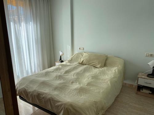 a white bed in a room with a window at San Vicente do Mar , playa in Pontevedra