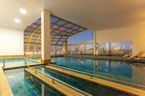 a swimming pool with a view of a building at Travel Inn Hotels Caxias do Sul in Caxias do Sul