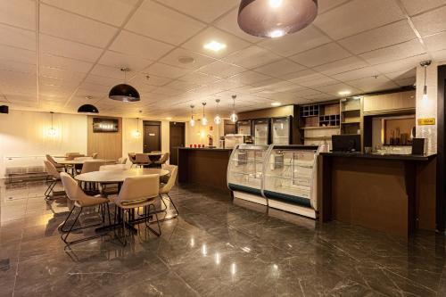 a restaurant with a table and chairs and a kitchen at Travel Inn Hotels Caxias do Sul in Caxias do Sul