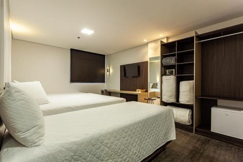 Un pat sau paturi într-o cameră la Travel Inn Axten Caxias do Sul