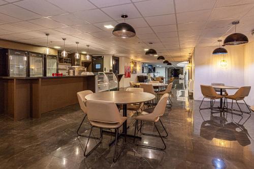 a restaurant with tables and chairs and a counter at Travel Inn Hotels Caxias do Sul in Caxias do Sul