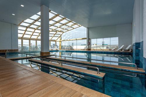 a swimming pool with benches in the middle of it at Travel Inn Hotels Caxias do Sul in Caxias do Sul