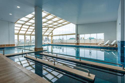 a swimming pool with benches in a large building at Travel Inn Hotels Caxias do Sul in Caxias do Sul
