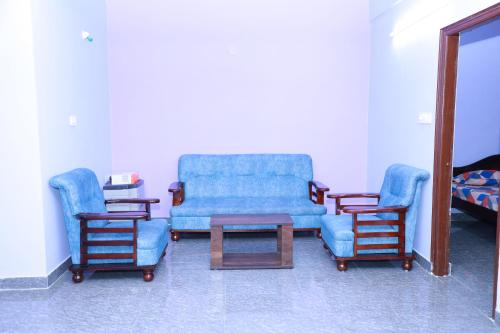a living room with two chairs and a blue couch at Two Bedroom Flat Non AC Varun Vihar Near Horsley Hills in Kurabalakota