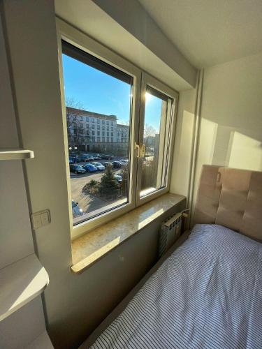 Kleines Zimmer mit einem Bett und einem Fenster in der Unterkunft LUXURY RED APARTMENT by Marta in Radom