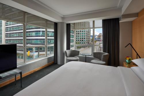 a hotel room with a bed and a large window at SoHo Hotel Toronto in Toronto