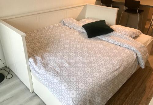 - un lit blanc avec un oreiller noir dans l'établissement Studio entre le phare de Biarritz et la plage d'Anglet, à Anglet