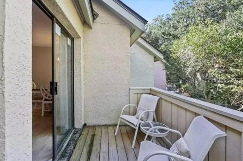 a balcony with two chairs and a sliding glass door at New Pics! Harbour Town 3BR/3BA - Pool Access - Book Now in Hilton Head Island