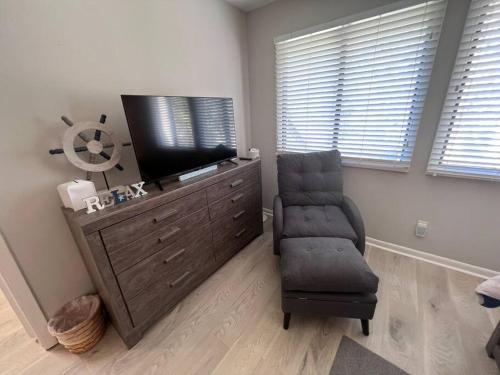 a living room with a tv and a chair at New Pics! Harbour Town 3BR/3BA - Pool Access - Book Now in Hilton Head Island