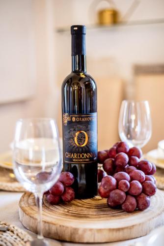 a bottle of wine and two wine glasses on a table at Pine & Oak Holiday Home in Fužine