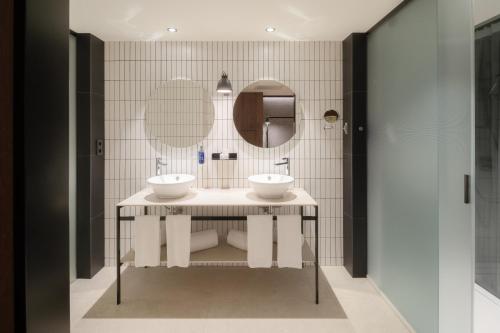 a bathroom with two sinks and a mirror at Radisson Blu 1882 Hotel, Barcelona Sagrada Familia in Barcelona