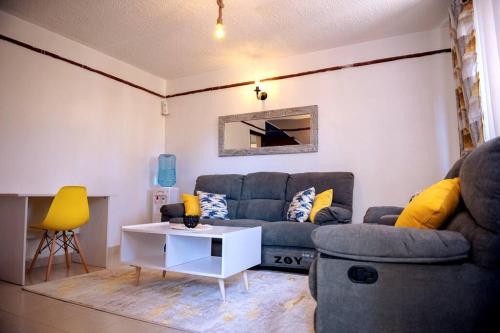 ein Wohnzimmer mit einem Sofa und einem Tisch in der Unterkunft JuVee Place -Two Bedroom Apartment, Nanyuki in Nanyuki