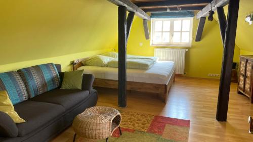 a living room with a bed and a couch at Ferienhaus "Ahle Schinn" in Bad Sooden-Allendorf