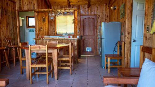 a kitchen with a table and a refrigerator at Cabañas Copayapu in Pucón