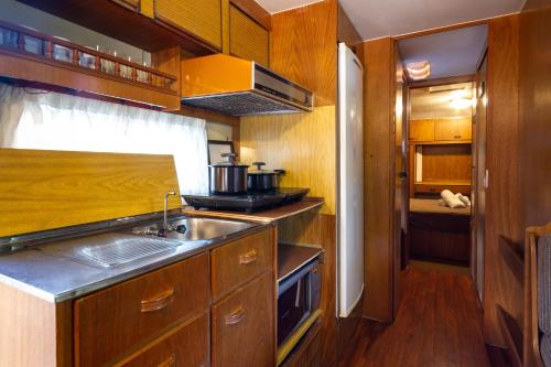 a kitchen with wooden cabinets and a sink at Villa Vintage Campos - Piscina e opções de suites com hidromassagem in Campos do Jordão