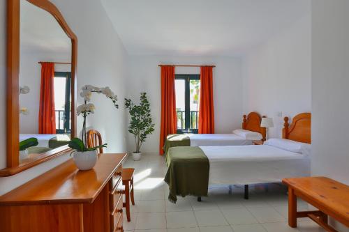 a hotel room with two beds and a mirror at Nazaret Sol in Costa Teguise