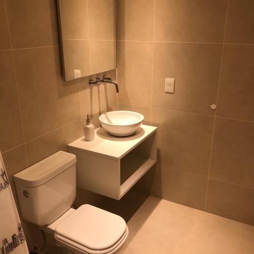 a bathroom with a white toilet and a sink at De la Costa II Ushuaia in Ushuaia