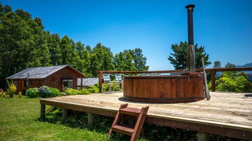 a wooden deck with a hot tub on top of it at Cabañas Copayapu in Pucón