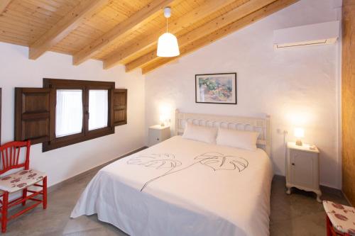 1 dormitorio con 1 cama blanca y 1 silla roja en Casa Verònica, en Pego