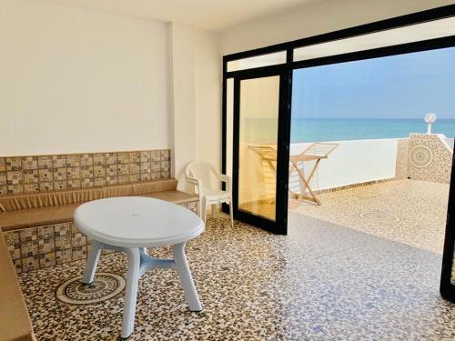 einen Tisch und einen Stuhl in einem Zimmer mit Meerblick in der Unterkunft Casa del Mar Residence in Kelibia