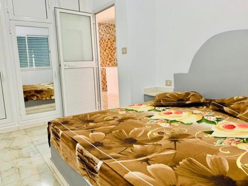 um quarto com uma cama com flores em Casa del Mar Residence em Kelibia