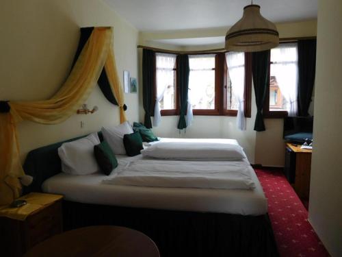 a bedroom with a large bed in a room with windows at Kranenturm hotel in Bacharach