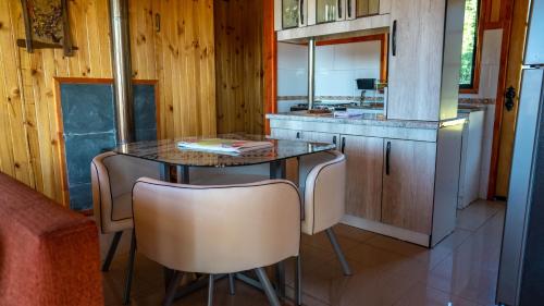 a kitchen with a table and chairs and a counter at Cabañas Copayapu in Pucón
