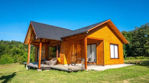 a small wooden house with a black roof at Cabañas Copayapu in Pucón