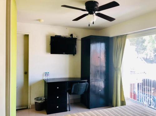 a bedroom with a black desk and a ceiling fan at Hotel Ruah in Cuernavaca