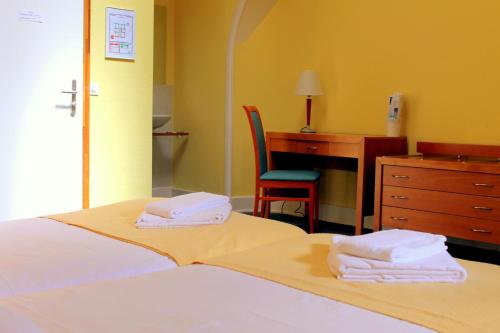 a bedroom with a bed and a desk and a chair at Le Cénacle in Geneva