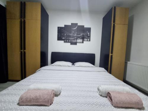 a bedroom with a large bed with two towels on it at Family Apartmani Le in Leskovac