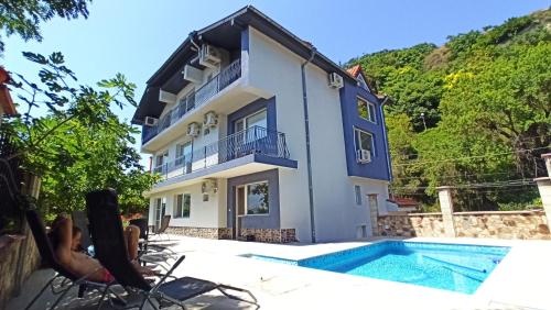 a villa with a swimming pool in front of a house at Arode Villa Ovidius - Apartments in Balchik