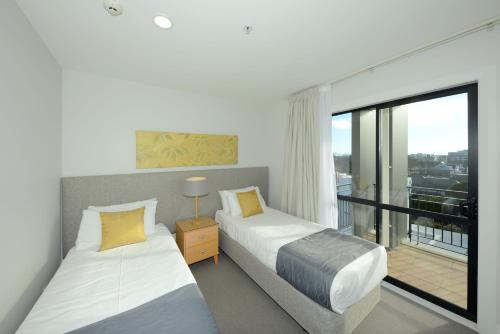 Giường trong phòng chung tại West Fitzroy Apartments