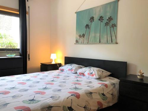 une chambre avec un lit avec une couette colorée dans l'établissement Apartamento Mar com Parking, à Nazaré