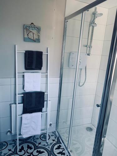 a bathroom with a shower with a glass shower stall at Atlantic Bay Cottage in Culdaff