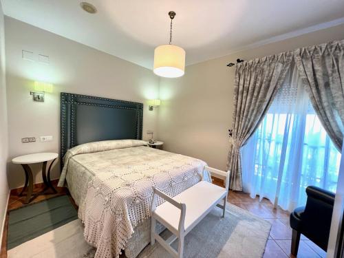 a bedroom with a bed and a table and a window at Hotel El Curro in Burunchel