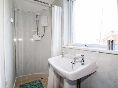 a white bathroom with a sink and a shower at The Annexe, Laburnum in Bugle