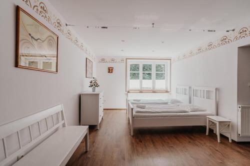 a white room with two beds and a window at Penzion Račí údolí in Javorník