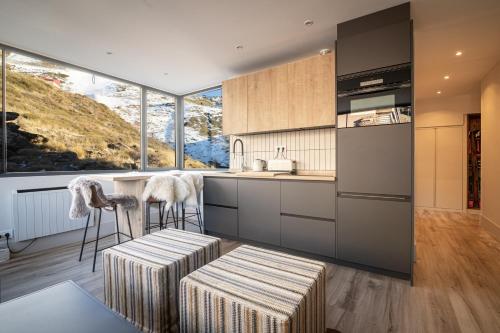 シエラネバダにあるAPARTAMENTO DE LUJO A PIE DE PISTA SIERRA NEVADAのキッチン(カウンター、スツール2つ付)