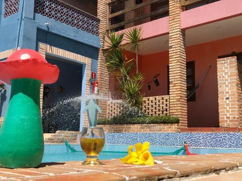 een tafel met een glas wijn naast een zwembad bij POUSADA MARINA PRAiA in Beberibe