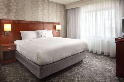 Sonesta Select Laguna Hills Irvine Spectrum في لاغونا هيلس: غرفة نوم بسرير كبير ونافذة كبيرة